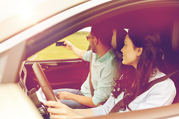 Image showing happy couple in car taking selfie with smartphone