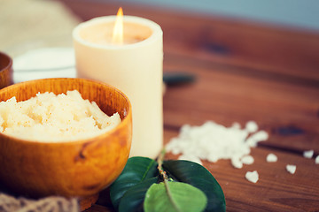 Image showing close up of natural body scrub and candle on wood