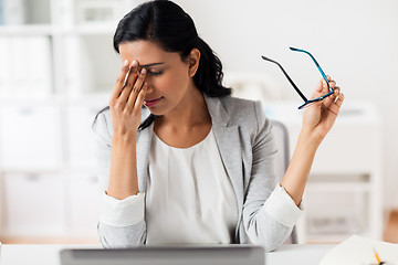 Image showing businesswoman rubbing tired eyes at office