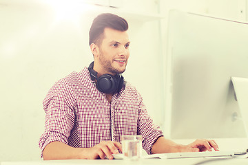 Image showing creative man with headphones and computer