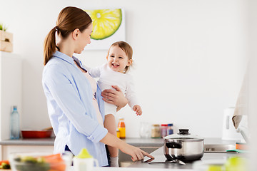 Image showing happy mother and baby cooking at home kitchen