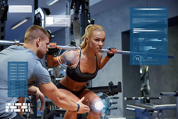 Image showing man and woman with bar flexing muscles in gym