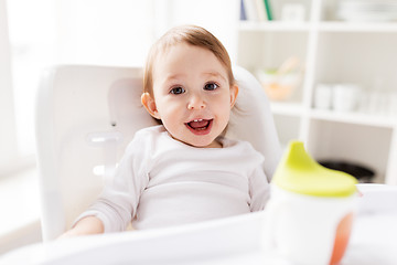 Image showing happy smiling baby sitting in highchair at home