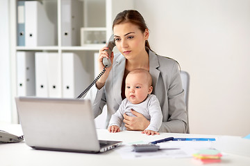 Image showing businesswoman with baby calling on phone at office