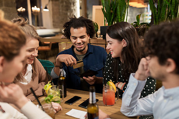 Image showing friends with drinks, credit card and bill at bar