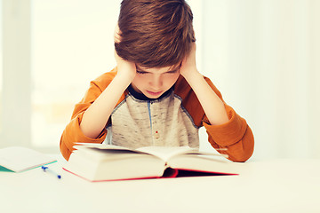 Image showing student boy reading book or textbook at home