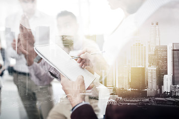 Image showing business team and man writing to notepad at office