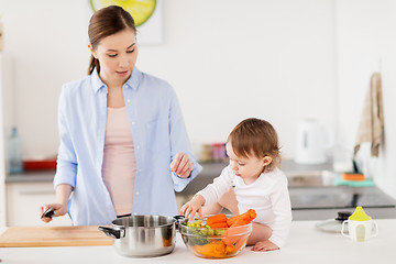 Image showing happy mother and baby cooking food at home kitchen