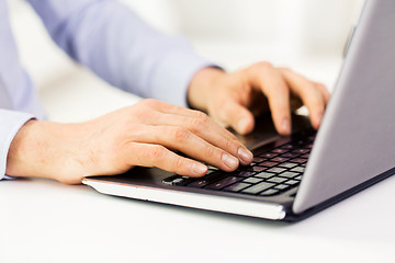 Image showing close up of male hands with laptop typing