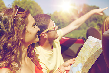 Image showing happy friends with map driving in cabriolet car