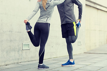 Image showing close up of couple stretching legs outdoors