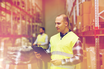 Image showing man with clipboard in safety vest at warehouse