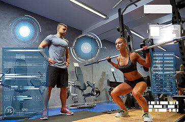 Image showing man and woman with bar flexing muscles in gym