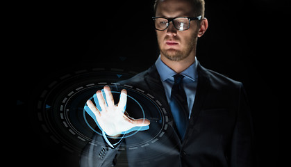 Image showing businessman touching virtual screen projection