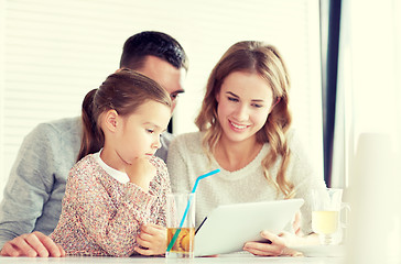 Image showing happy family with tablet pc at restaurant