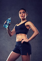 Image showing woman drinking water from bottle in gym