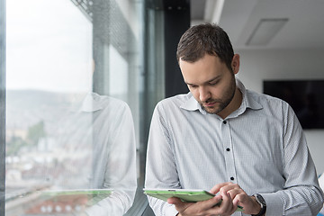 Image showing Businessman Using Tablet In Office Building by window