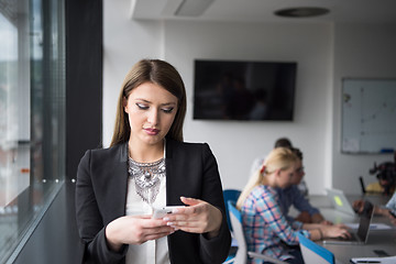 Image showing Business Girl Standing In A Modern Building Near The Window With