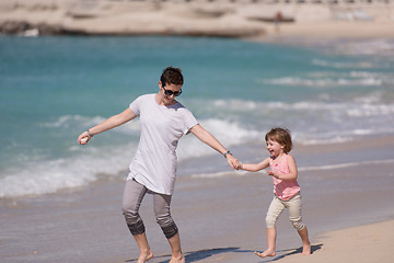 Image showing mother and daughter running on the beach