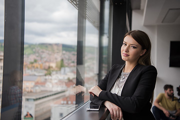 Image showing Elegant Woman Using Mobile Phone by window in office building