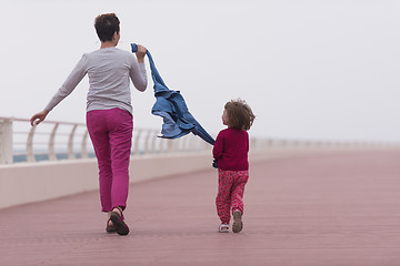 Image showing mother and cute little girl on the promenade by the sea