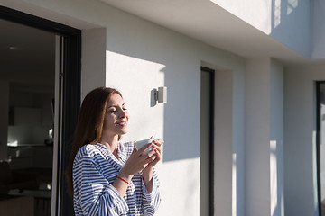 Image showing woman in a bathrobe enjoying morning coffee