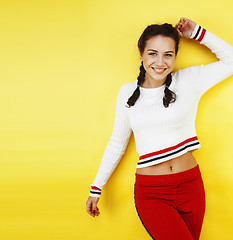 Image showing lifestyle people concept: pretty young school teenage girl having fun happy smiling on yellow background 