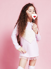 Image showing little cute girl with candy on pink background posing emotional, lifestyle people concept