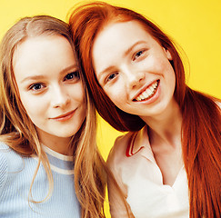 Image showing lifestyle people concept: two pretty young school teenage girls having fun happy smiling on yellow background