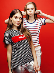 Image showing two best friends teenage girls together having fun, posing emotional on red background, besties happy smiling, lifestyle people concept