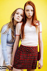 Image showing lifestyle people concept: two pretty young school teenage girls having fun happy smiling on yellow background 