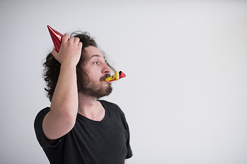 Image showing Portrait of a man in party hat blowing in whistle