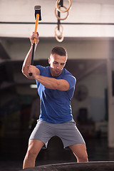 Image showing man workout with hammer and tractor tire