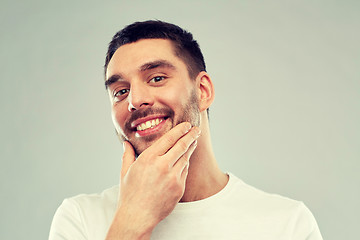 Image showing happy young man touching his face or beard