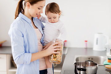 Image showing mother and baby cooking pasta at home kitchen