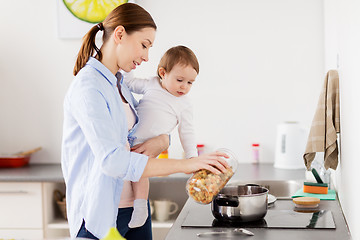 Image showing mother and baby cooking pasta at home kitchen