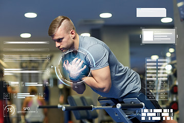 Image showing young man flexing back muscles on bench in gym