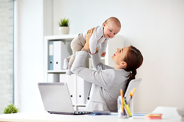 Image showing happy businesswoman with baby and laptop at office