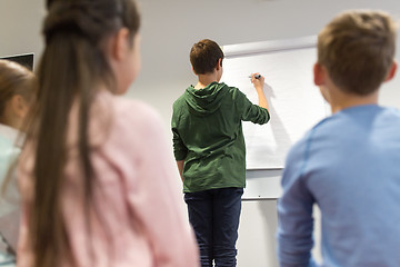 Image showing student boy with marker writing on flip board