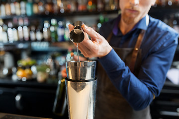 Image showing barman with shaker preparing cocktail at bar