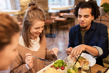 Image showing happy friends eating and drinking at restaurant