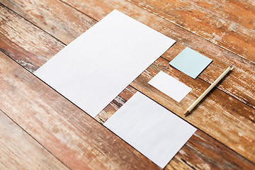 Image showing blank paper sheets and pencil on wooden board