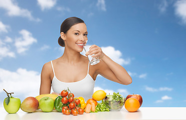 Image showing happy woman with glass of water and healthy food