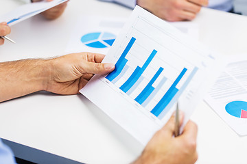 Image showing male hands holding paper with charts at office