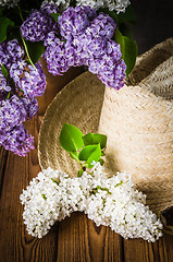 Image showing Still-life with a bouquet of lilacs and a straw hat, close-up