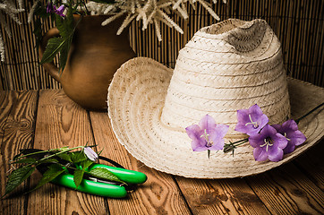 Image showing Straw hat and flowering campanula, close-up