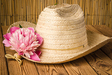 Image showing Straw hat and peony flower, close-up