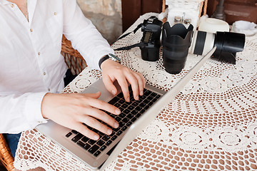 Image showing Man working on laptop at the wooden table outdoors