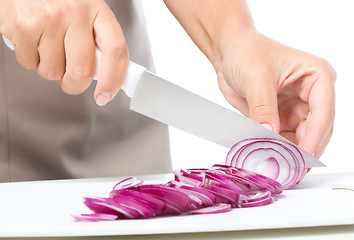 Image showing Cook is chopping onion