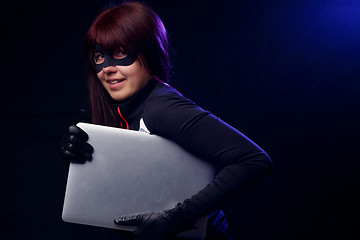 Image showing Brunette thief in black gloves
